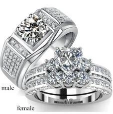 Close-up of matching couple rings with heart-shaped crystal and men's pavé band
