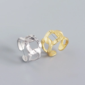 Close-up of adjustable silver and gold chain rings with textured hammer finish