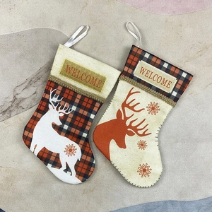 Two small burlap Christmas stockings with reindeer designs and Welcome embroidery