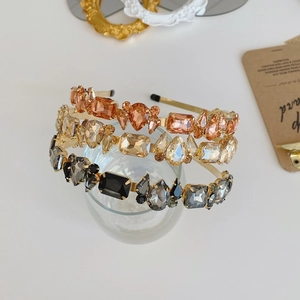 Close-up of three baroque crystal headbands in amber, gold, and smoky grey tones