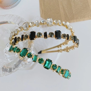 Detail of luxury baroque headbands with inlaid white, black, and emerald gemstones