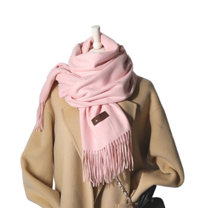 Pink Morandi cashmere scarf with tassels and leather label on a beige coat model