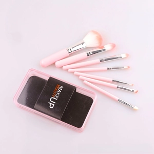Detailed view of 7-piece makeup brush set with pink handles in a clear storage box
