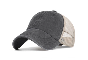 Macro side view of grey washed denim and beige mesh panels on the baseball cap