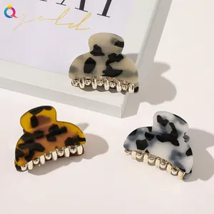 Three large acrylic leopard print hair claws with gold metal teeth in a set