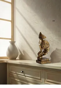 Vue détaillée de la sculpture en résine dorée le silence est d'or sur un meuble en bois