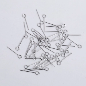 Macro shot of silver eye pins for DIY jewelry making scattered on a white background