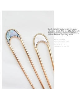 Detailed macro view of U-shaped metal hair pin with natural mother of pearl inlay