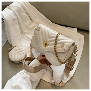 Detail of off-white quilted shoulder bag set with chain and round coin purse accessory