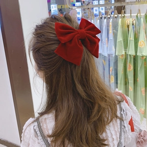 Elegant large red velvet bow hair clip shown on the back of a model's head for styling