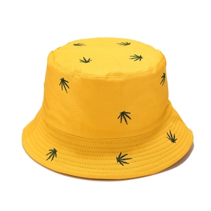 Yellow cotton bucket hat with green leaf embroidery shown from a top-down angle
