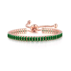 Detail view of rose gold adjustable bracelet with vibrant green rectangular crystals