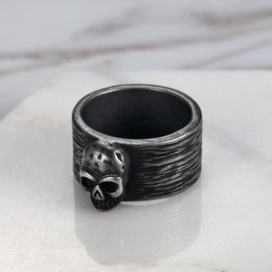 Detailed close-up of a vintage silver skull ring with an antique punk finish on marble