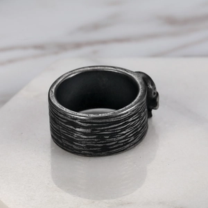 Close-up of vintage silver skull ring with distressed texture on white marble