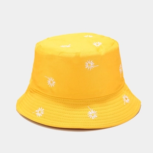 Detailed close-up of white daisy embroidery on bright yellow cotton canvas sun hat