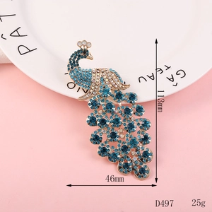 Detailed view of a peacock brooch with blue rhinestones measuring 113mm by 46mm
