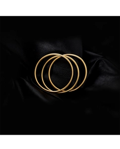 Close-up of three minimalist 18K gold-plated stainless steel bangles on black leather