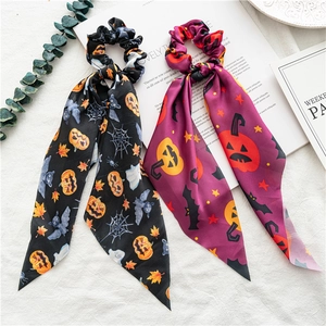Halloween scrunchies with long streamers featuring pumpkin and bat prints on satin fabric
