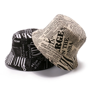 Black and beige cotton bucket hats with vintage newspaper print in a layered display