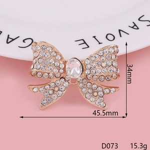 Rose gold bowknot brooch with rhinestones on a white plate over pink background