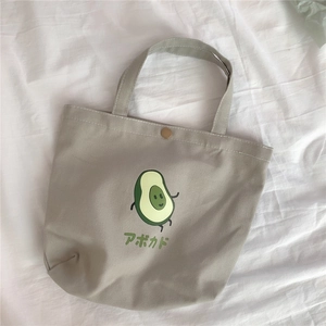 Detailaufnahme der Canvas-Lunchtasche mit Avocado-Print und bronzefarbenem Metalldruckknopf