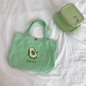Detail der hellgrünen Segeltuchtasche mit Avocado-Druck und Metall-Druckknopfverschluss