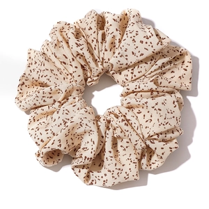 Polka dot oversized fabric scrunchie in beige with brown spots on white background