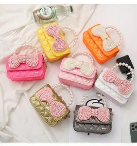Detailed view of mini crossbody bags with pearl handles and bow in multiple colors