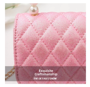 Close-up of pink glitter quilted fabric with elegant pearl and gold chain details