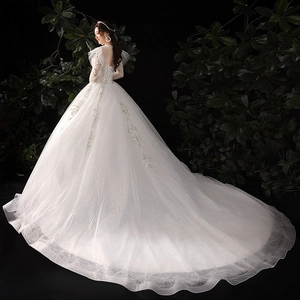 Robe de mariée en dentelle avec longue traîne, dos nu, paillettes et taille haute
