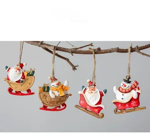 Detail of resin Christmas sled ornaments with Santa and snowman on a rustic branch