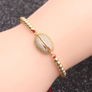 Adjustable gold bead chain bracelet with a shell pendant and sparkling zircon stones