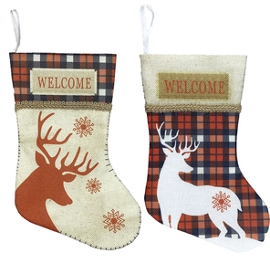 Detail of linen Christmas stockings with red plaid patterns and Welcome embroidery