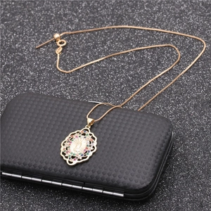 Golden necklace with Mariana heart oval pendant and colorful stones on a black gift box