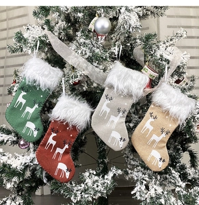 Detail of four hanging Christmas stockings with reindeer silhouettes and faux fur cuffs
