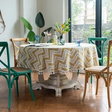 Detail of yellow and white wave pattern tablecloth with decorative tassel lace edges