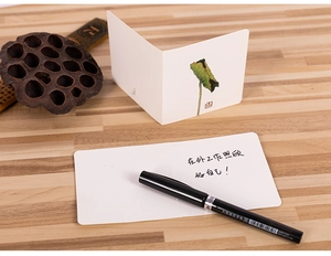 Close-up of a vintage Chinese style mini greeting card with lotus illustration on wood