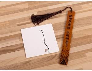 Bamboo bookmark with silk tassel and ink painting greeting card on wood surface