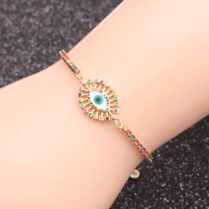 Macro shot of evil eye chain bracelet featuring gold metal and colorful cubic zirconia