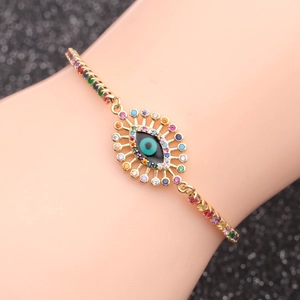 Detail of gold evil eye chain bracelet with colorful pavé cubic zirconia on wrist