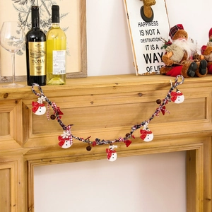 Christmas snowman resin hanging garland with red hearts and bells on a fireplace mantle