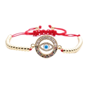 Detail of red braided Evil Eye bracelet with gold beads and sparkling zircon inlay