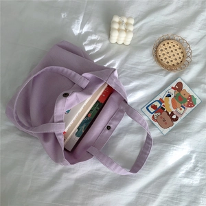 Detail of light purple corduroy tote bag showing interior space and snap button closure