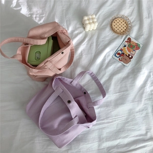 Detail of canvas tote bag showing spacious interior with pink and purple color options