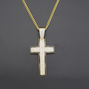 Close-up of hip hop gold cross pendant with black enamel and encrusted diamonds