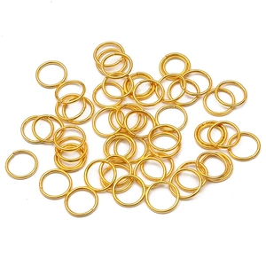 Goldene offene Binderinge und Verbinder für DIY-Schmuck auf weißem Hintergrund präsentiert