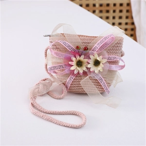 Detail of pink straw crossbody bag with floral lace and sunflower accents for girls