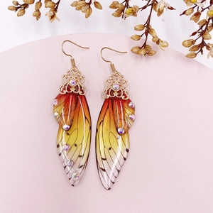 Macro detail of S925 silver gradient butterfly wing earrings with golden hooks