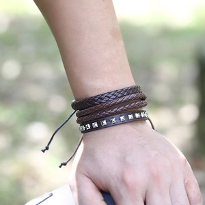 Detail of multi-layer woven leather bracelets with metal studs on a man wrist