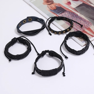 Set of 5 black braided leather bracelets with studs on a clean white background